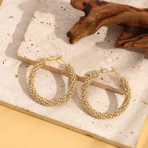 Gedetailleerd overzicht van glinsterende gouden oorringen met strass, elegant en modieus.