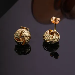 Elegantes pendientes de botón con nudo trenzado dorado, detalle geométrico en espiral.