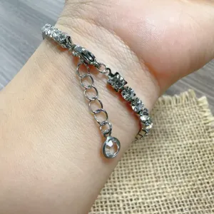 Close-up detail of a silver-toned rhinestone chain bracelet worn gracefully on the wrist.