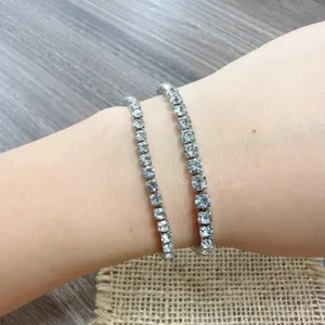 Detailed view of double layered rhinestone tennis bracelets worn on wrist, elegant sparkling jewelry.