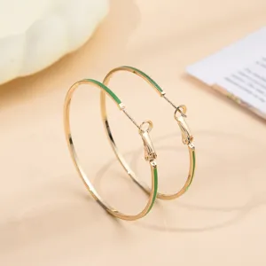 Elegante gouden creolen met levendig groen emaille, chic modern ontwerp voor vrouwen.