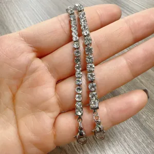 Detailed shot of a sparkling rhinestone tennis bracelet with secure lobster clasp, elegant jewelry.