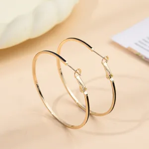 Gedetailleerd overzicht van stijlvolle gouden creolen met zwart emaille, minimalistisch.