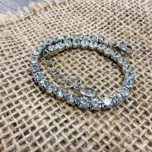 Stainless steel cubic zirconia tennis bracelet with silver tone finish and extension chain.