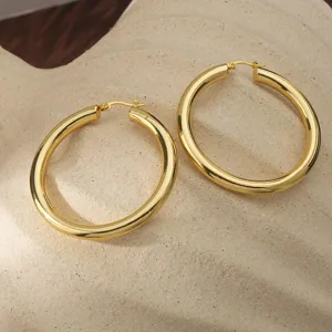Gedetailleerd overzicht van grote gouden oorbellen, gladde afwerking, elegant hol design sieraden.