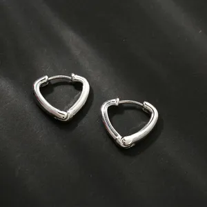 Gedetailleerd overzicht van onregelmatige zilveren hartoorringen, minimalistische sieraden.