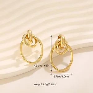 Close-up van gouden geometrische oorbellen met gedetailleerde afmetingen en maten.