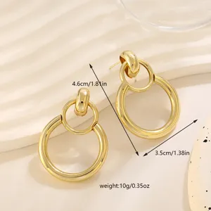 Gedetailleerde opname van gouden geometrische dubbele cirkel oorbellen en afmetingen.