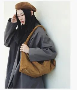 Detailed view of casual retro brown suede shoulder bag, minimalist lazy style tote bag for women.