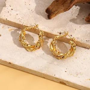 Detailopname van trendy gouden creolen oorringen met uniek gestructureerd kralendesign.