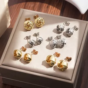 Juego de pendientes de botón de nudo metálico en oro y plata, joyería geométrica elegante.