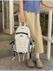 Gedetailleerde opname van de Japanse polkadot rugzak met voorzak en schattige lintdetails.