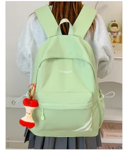 Lichtgroene casual rugzak detail, grote schooltas met schattige appelhanger voor dagelijks.