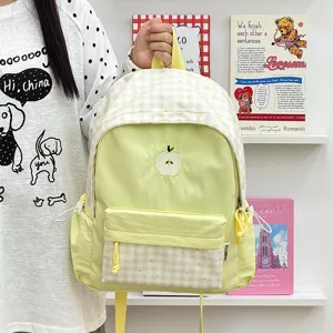 Charmant sac à dos à carreaux jaune clair avec jolie broderie de pomme et poches pratiques.