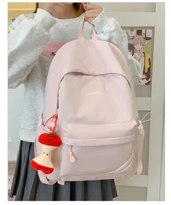 Gedetailleerd uitzicht op casual roze rugzak, grote capaciteit en schattige appel sleutelhanger.