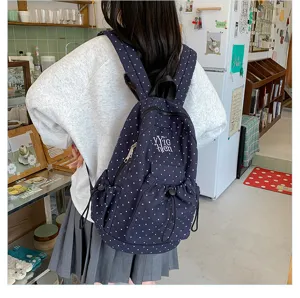 Stylish navy blue polka dot backpack for women and students, casual daily school bag.