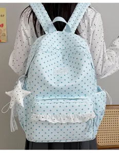 Detailed view of the cute blue star print backpack with white lace trim and star pendant.