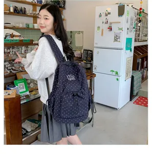 Detail shot of a deep blue polka dot backpack featuring large capacity and casual daily style.