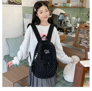 Detail shot of casual black polka dot backpack with drawstring closure and pocket.