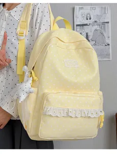 Detail view of the cute yellow star print backpack with delicate white lace trim and star pendant.