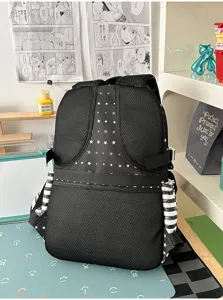 Detailopname van de zwarte sterren mesh rugzak met gestreepte zijvakken op het bureau.