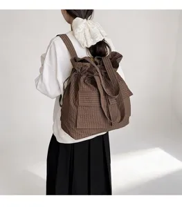Detailed view of the brown plaid drawstring backpack, showing the texture and large capacity.