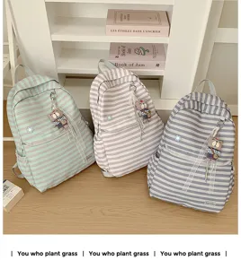 Detail van gestreepte canvas rugzak met berenhanger, grote schooltas voor meisjes.