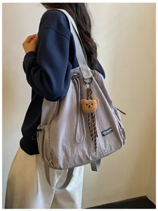 Gedetailleerd overzicht van casual nylon rugzak met schattige berenhanger voor dagelijks gebruik.