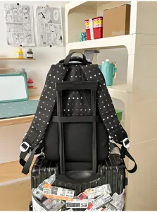 Zwarte schoolrugzak met sterrenpatroon en kofferriem voor dagelijks gebruik en reizen.