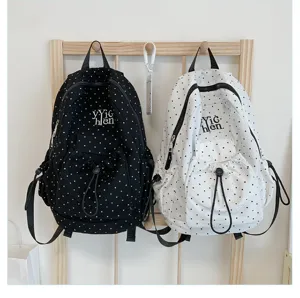 Casual polka dot canvas backpack with large capacity, trendy student school bag design.
