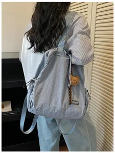 Casual nylon convertible rugzak en schoudertas in blauw met een leuke berenhanger.