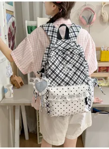 Gedetailleerd overzicht van de zwart-wit geruite rugzak met stipzak en leuk hangend accessoire.