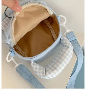 Lichtblauwe geruite schoudertas detailweergave, met binnenvoering en ritssluiting.