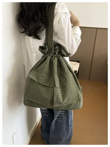 Green plaid drawstring canvas backpack large casual shoulder bag detail view for travel.
