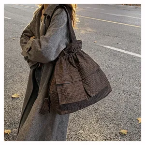 Close-up view of the stylish utility plaid drawstring backpack showcasing detailed texture and straps.