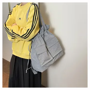 Detailed view of a stylish plaid drawstring backpack, showing large capacity and practical pockets.