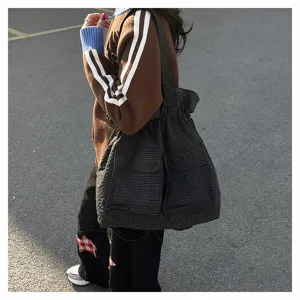 Detail shot of the tactical plaid tote bag showcasing its spacious capacity and front pockets.