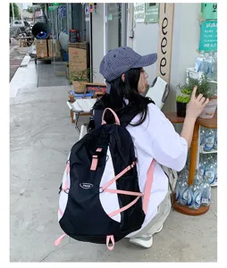Outdoor backpack detail, black and white design with pink straps, street style.