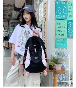 Outdoor casual black and white contrast color backpack detail showing pink straps and buckle.