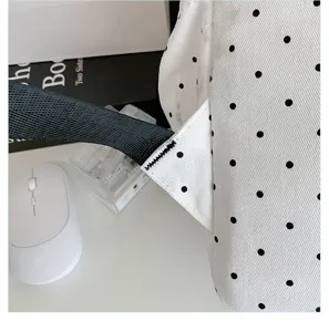 Detail view of stylish white polka dot backpack strap and stitching craftsmanship.