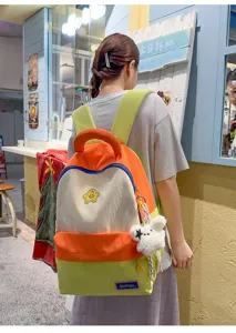 Detailed view of cute color-block student backpack, multi-compartment casual daypack.
