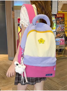 Detailed shot of the colorful backpack worn by model, showing the cute star patch and bunny charm.