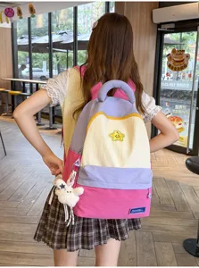 Cute colorblock student backpack with front pocket and plush pendant backpack detail view