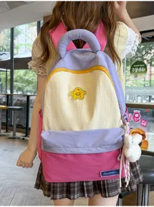 Cute Korean style contrast color student backpack with star badge and plush pendant for daily use.