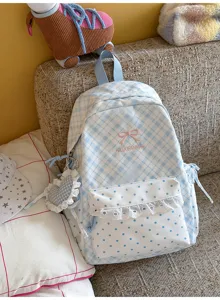 Gedetailleerd uitzicht blauwe ruitjes polkadot schoolrugzak met strik borduurwerk en hanger.