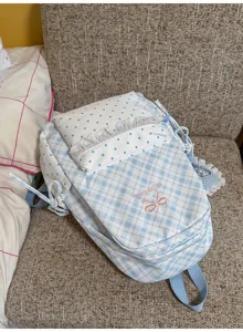 Gedetailleerd uitzicht op de schattige blauw-witte ruitjesrugzak met strikborduurwerk.