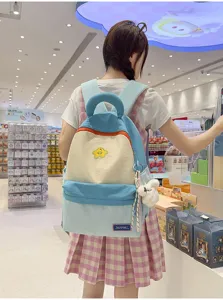 Close-up detail of the stylish color-blocked student backpack with star patch and cute charm pendant.