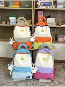 Cute color-blocking student schoolbag with large capacity, star badge and plush pendant.