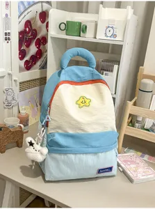 Cute color block student backpack with star patch and plush pendant, large capacity casual bag.