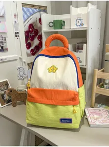 Detailed view of cute color-blocked school backpack with top handle and front pocket for daily use.